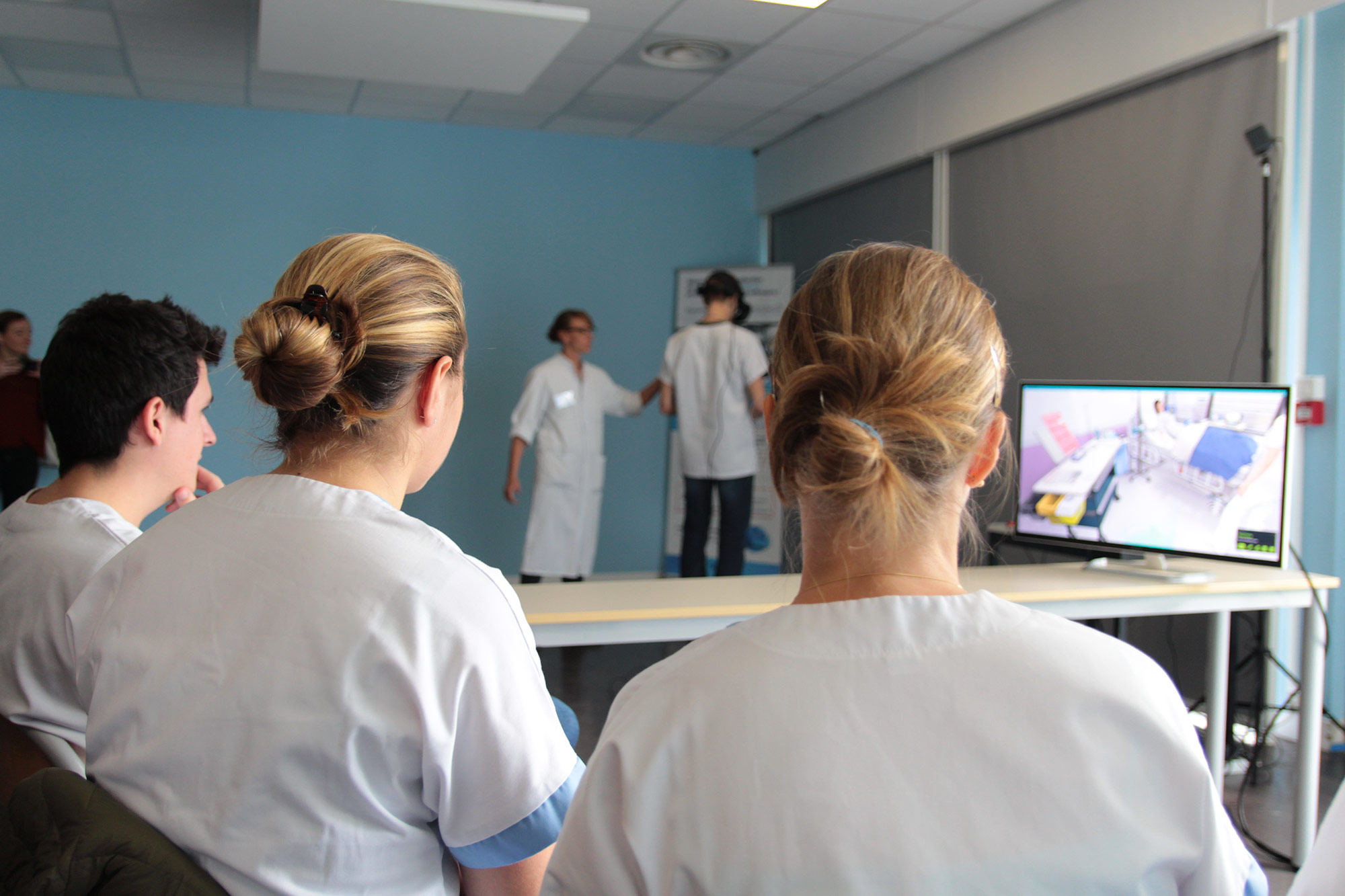 Groupe d'étudiant infirmiers qui regarde un camarade réalisant la procédure d'un acte transfusionnel en réalité virtuelle